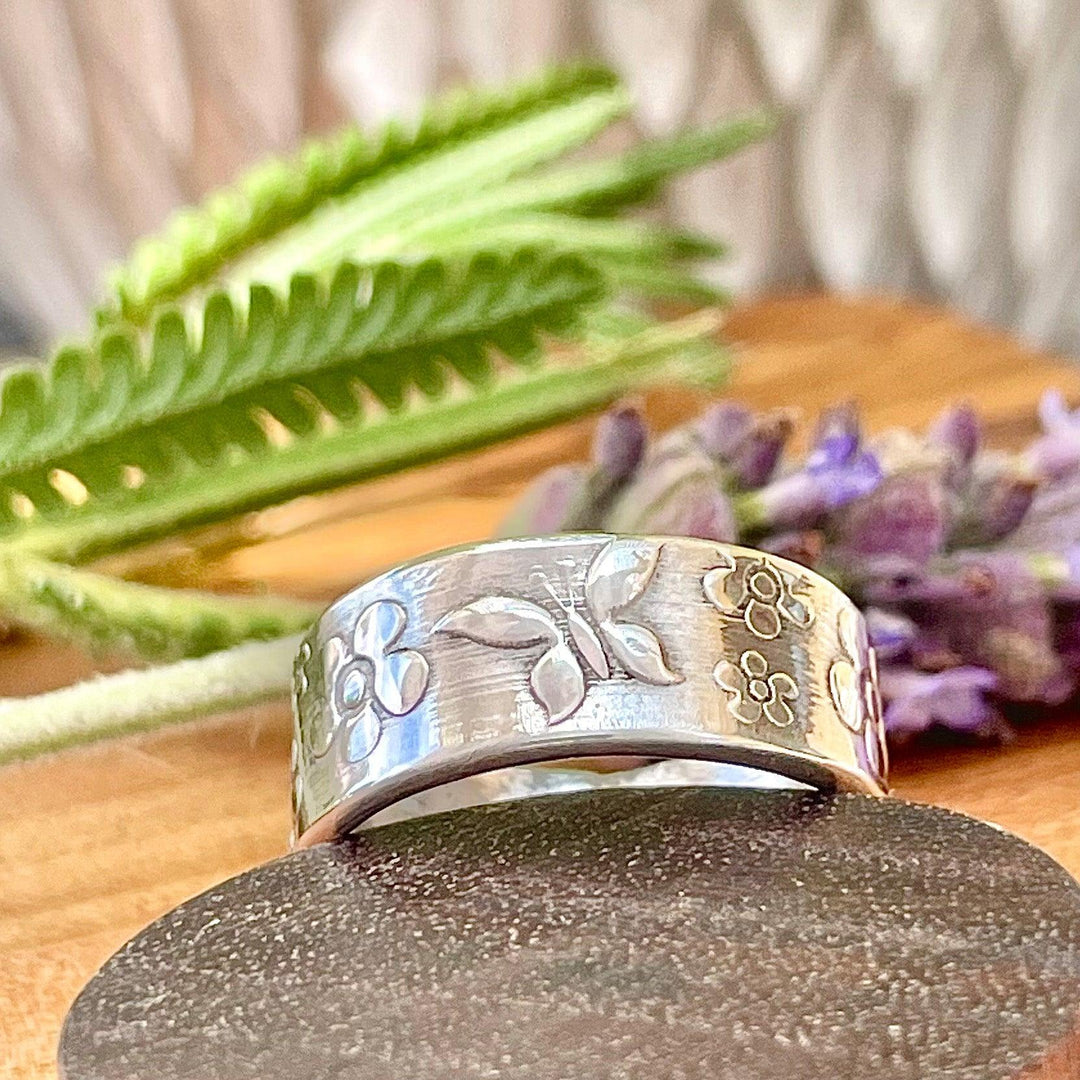 Cremation ring with butterflies and flowers.  The cremains are secure and watersafe compressed within the core of the ring.    Inside ring engraving available.