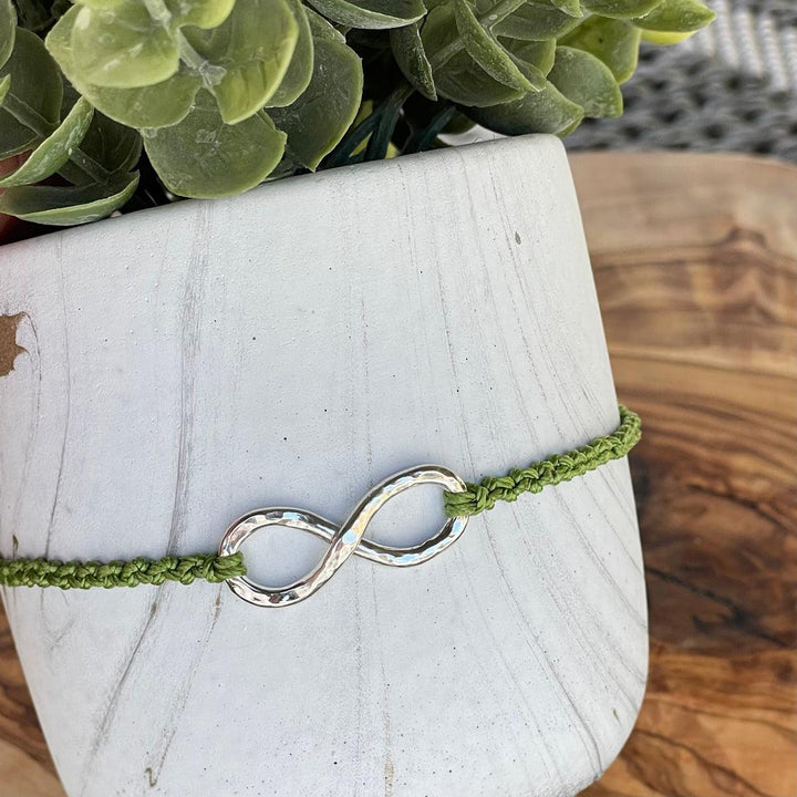 The infinity pendant has a cremation ash core.  The ash is secure, contained completely within this water safe  pendant.  This piece is shown with the green nylon adjustable bracelet.