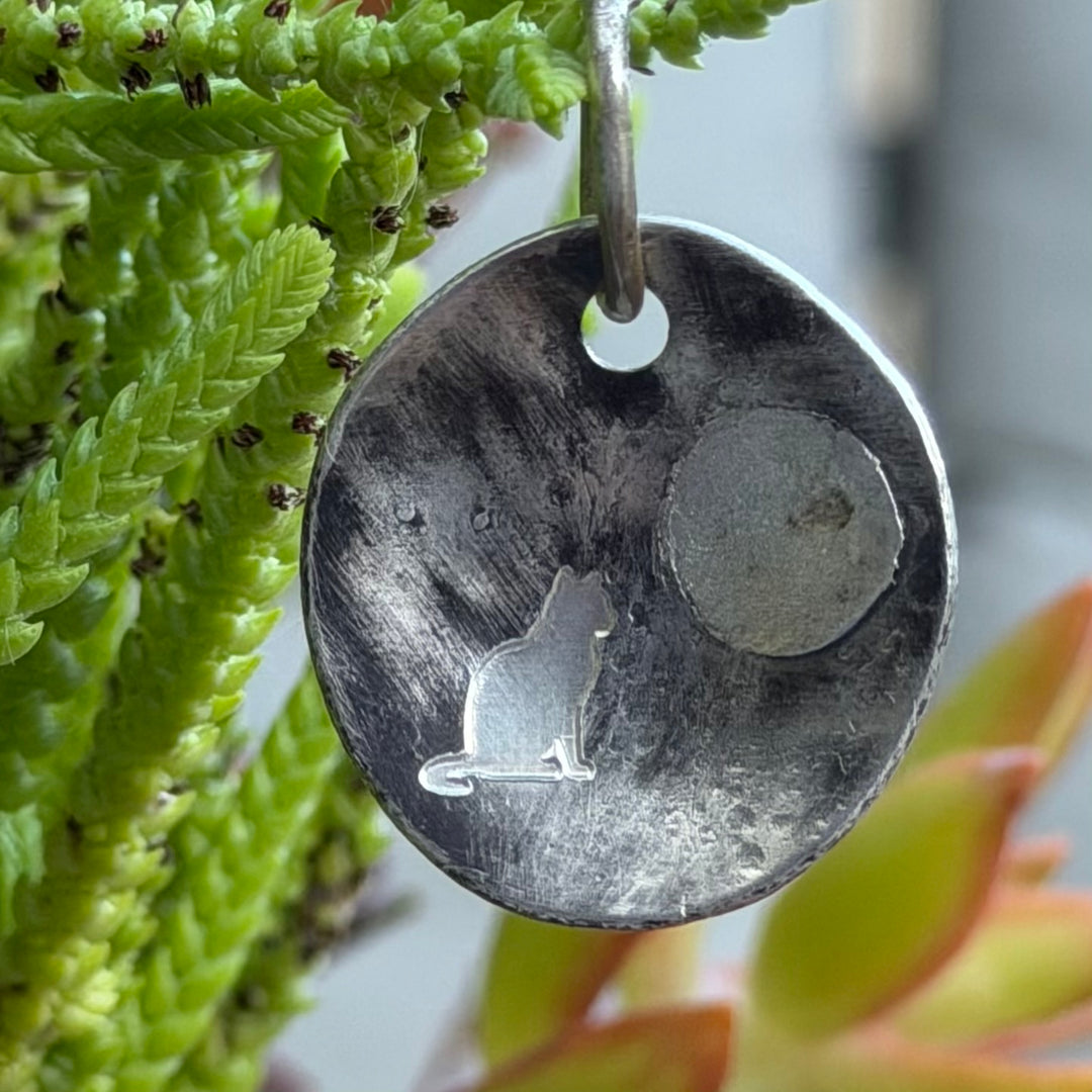 Silver creation pendant with deeply engraved cat and ashes sealed behind the moon.   