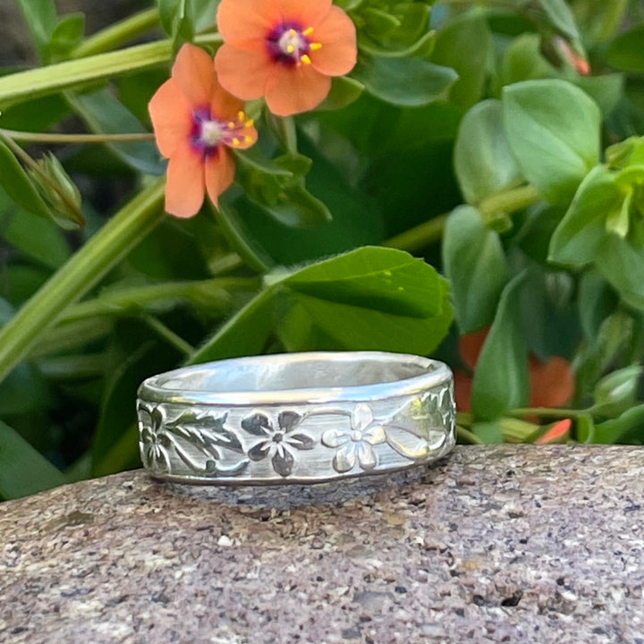 Flower and leaf silver ring with cremation ash core.  It is upscale, substantial and hand forged. This ring may be worn in water.